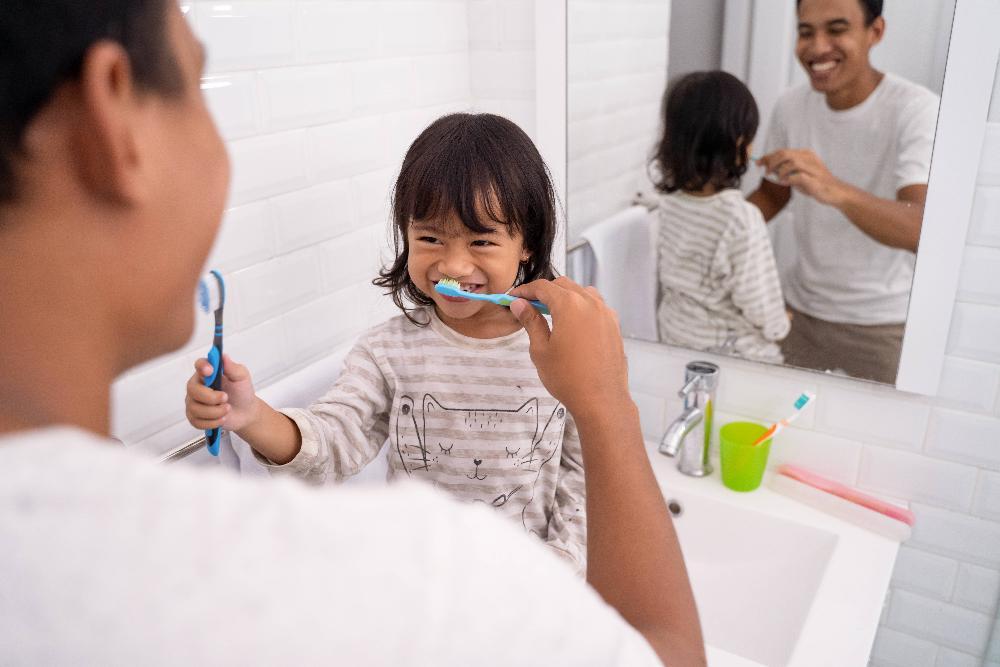 father and child brushing teeth in Lincoln NE