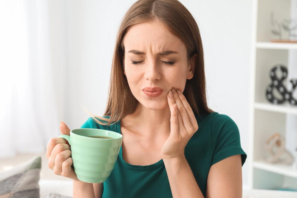 woman holding painful tooth 