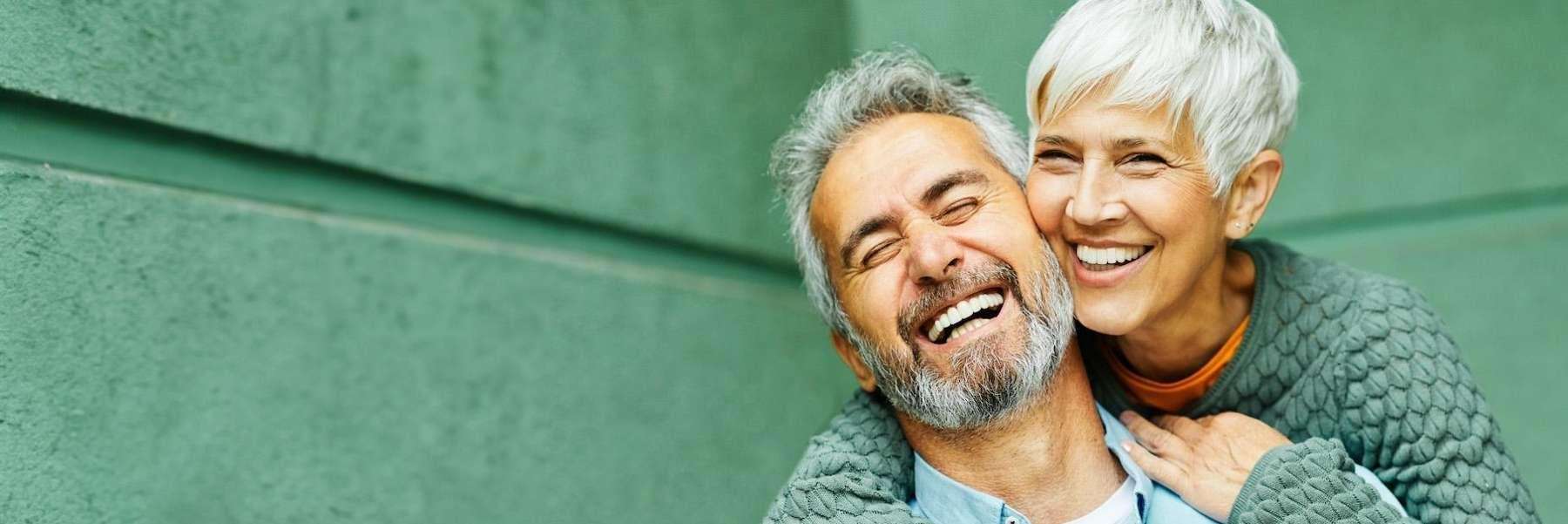 smiling couple with new dental implants in lincoln ne