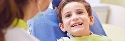 young boy smiling in dental chair