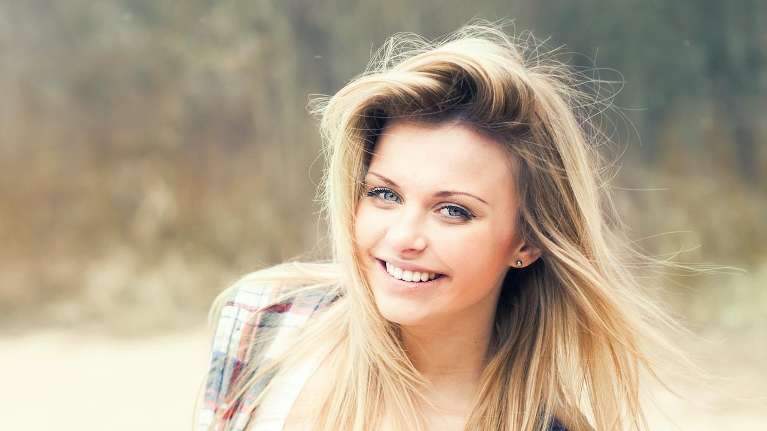 woman smiling after getting a dental bridge