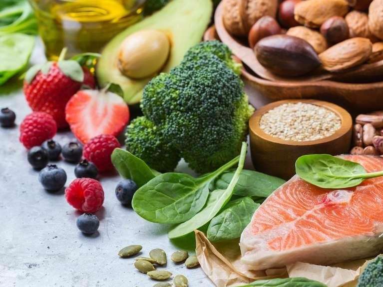 Fresh tooth-friendly foods like salmon, berries, broccoli, avocado, nuts, and spinach from Lincoln f