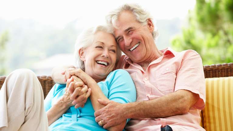 older man and woman smiling while sitting outside in lincoln