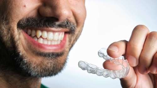 man putting on his clear aligners 